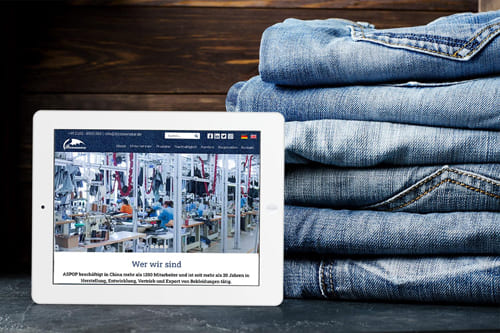 Referenz Webseite von Bizoceanstar GmbH über Textilproduktion und Jeansherstellung auf einem Tablet Stapel Jeans neben einem Tablet, das eine Webseite über Textilproduktion von Bizoceanstar GmbH anzeigt